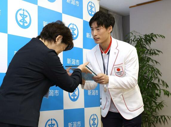 新潟市スポーツ大賞の贈呈式で、表彰盾を受け取る古俣聖選手(右)=9月30日、新潟市役所