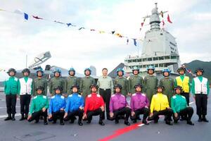 中国軍の新型空母「福建」が就役し、パイロットらと記念撮影する習近平国家主席(後列中央)=5日、中国海南省三亜市(新華社=共同)