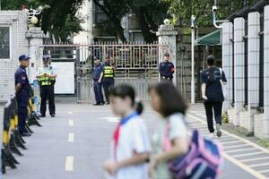 日本人学校に通う男子児童が登校中に刺殺された事件後、同学校付近を警戒する治安当局者=2024年10月、中国広東省深セン市(共同)