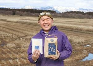 　秋田県能代市の栗山地区で栽培したコメ「大谷米」を手に笑顔を見せる大谷直人さん＝５日
