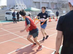 たすきをつないで快走する参加者=新潟県佐渡市名古屋