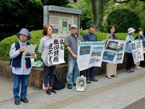 広島市役所前で抗議活動する「広島・パールハーバーの協定撤回を求める会」メンバー=16日午後