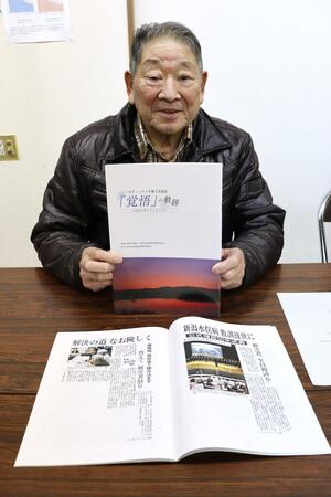 新潟水俣病第5次訴訟について新潟日報紙面などで紹介した冊子「『覚悟』の軌跡」を手にする皆川栄一団長=新潟市中央区沼垂東6