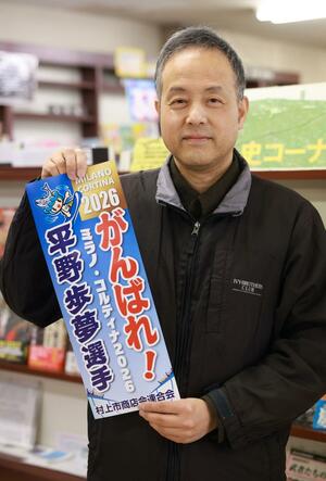 平野歩夢選手を応援するポスターを手にする益田良一さん＝村上市小町