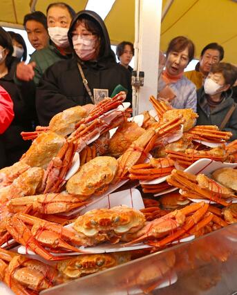 店頭に並んだカニを品定めする買い物客＝３０日、長岡市寺泊下荒町