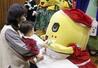 赤ちゃんにクリスマスプレゼントを手渡すふなっしー＝２０２５年１２月２４日、船橋市