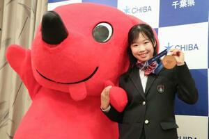 　ミラノ・コルティナ冬季五輪の銅メダルを掲げ、千葉県の公式キャラクター「チーバくん」と写真に納まる中井亜美選手＝１９日午前、千葉県庁