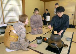 抹茶を点てる体験を楽しむ参加者=13日、新潟市中央区