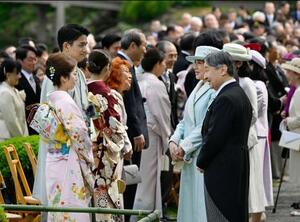 　春の園遊会で、五輪フィギュアスケート・ペアで金メダルの三浦璃来選手（左手前）、木原龍一選手（同手前から２人目）と言葉を交わされる天皇、皇后両陛下＝１７日午後、東京・元赤坂の赤坂御苑