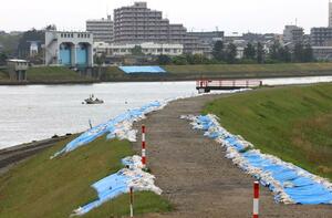 能登半島地震で液状化被害が出た信濃川右岸の堤防。対岸にも被災箇所がある=4月30日、新潟市中央区美咲町2(平成大橋から撮影)