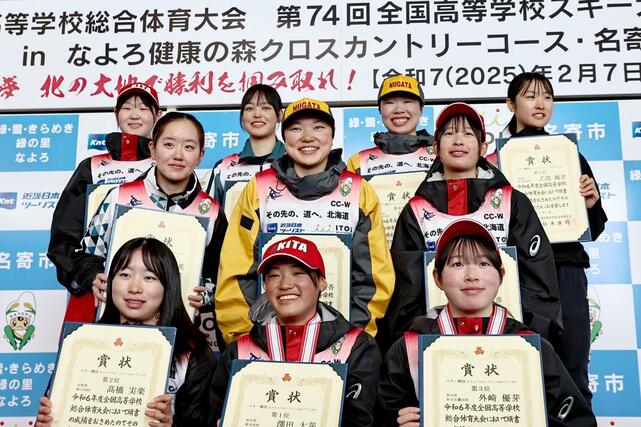 スキーインターハイ　女子５キロクラシカルの表彰式で壇上で記念撮影に応じる５位福原優香（２列目中央・十日町）と８位の牧田鈴葉（後列右から２番目・十日町）＝２月９日、北海道名寄市の道立サンピラーパークサンピラー交流館