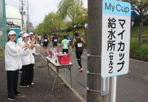 
セルフ給水所近くでランナーに声援を送るボランティアたち＝12日、新潟市中央区

