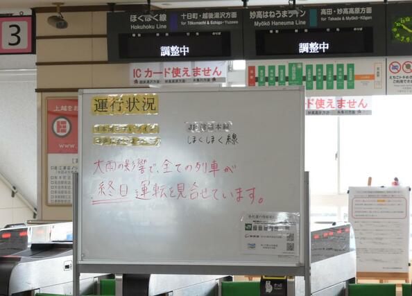 大雨により変電所が浸水したため、直江津発着の全ての列車が運休となったことを告げる看板=3日、上越市の直江津駅