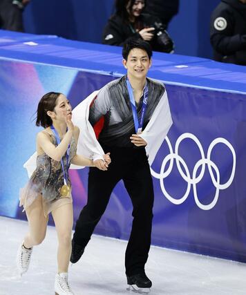 ペアで獲得した金メダルを胸に、歓声に応える三浦璃来（左）、木原龍一組＝ミラノ（共同）