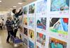 県ジュニア美術展覧会上越展の開幕を前に行われた準備作業＝２８日、上越市土橋