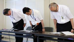 記者会見で謝罪し、頭を下げる松山市教委の白石秀一事務局長(中央)ら=28日午後、松山市役所