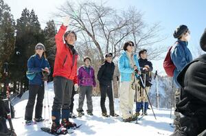 谷の展望台で見渡せる山々などを解説する山本信子さん＝津南町秋成