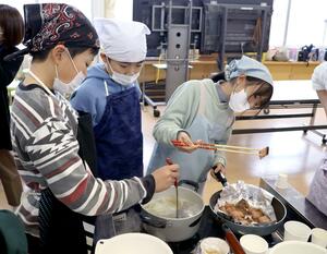 三面川で取れた鮭を調理する瀬波小の児童ら＝村上市瀬波上町