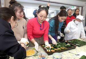 郷土料理の笹ずし作りを楽しむモンゴルの大学生ら=上越市浦川原区横住