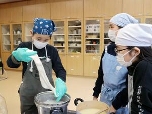 生乳からチーズを作る子どもたち=2月19日、佐渡市赤泊