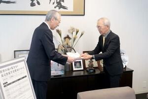 二階堂馨市長（左）に目録を手渡す「新発田城復元の会」の中川修治会長＝新発田市役所