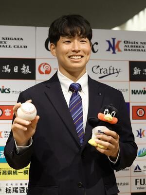 ヤクルトから育成3位指名を受け、写真撮影に応じるオイシックスの下川隼佑=新潟日報メディアシップ