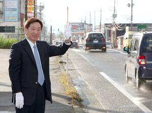初当選した上越市長選挙から一夜明け、通行人や車に手を振って感謝を伝える小菅淳一さん=27日、上越市藤巻