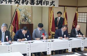合併契約書に調印する板倉、三和、中郷、清里牧の4商工会の会長ら=上越市牧区