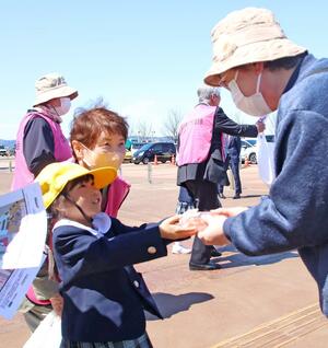 事故ゼロを願ってドーナツを手渡す見附天使幼稚園の園児＝６日、見附市今町１