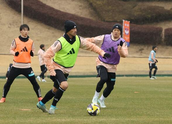 雨の中で競り合うMF落合陸(右)、DF舞行龍ジェームズ