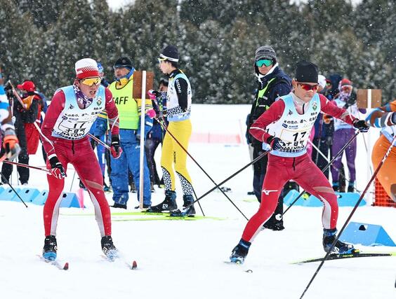 男子40キロリレー 十日町の2走岡田幸輝(左)から3走根津和弘(右)にリレー=2月11日、北海道名寄市