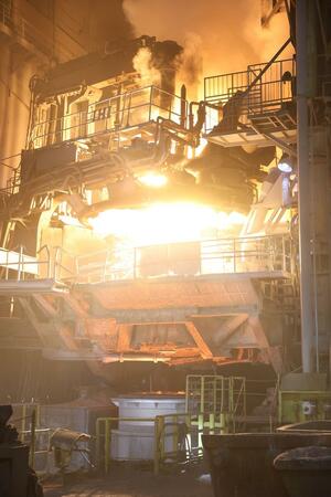 炎を上げる北越メタルの電気炉。熱波とごう音に圧倒される=長岡市蔵王3