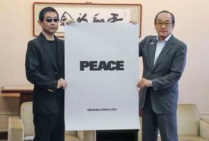 広島市役所で松井一実市長(右)に「ヒロシマ・アピールズ」のポスターを贈呈する北川一成さん=9日午前