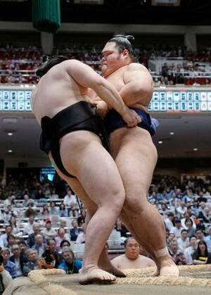 一意(右)が寄り切りで西ノ龍を破り、十両優勝を決める=両国国技館