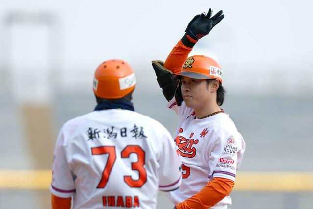 オイシックス－日本ハム　８回１死一三塁、代打の髙山俊が勝ち越し打を放ち塁上で手を挙げる＝３月２２日、エコスタ