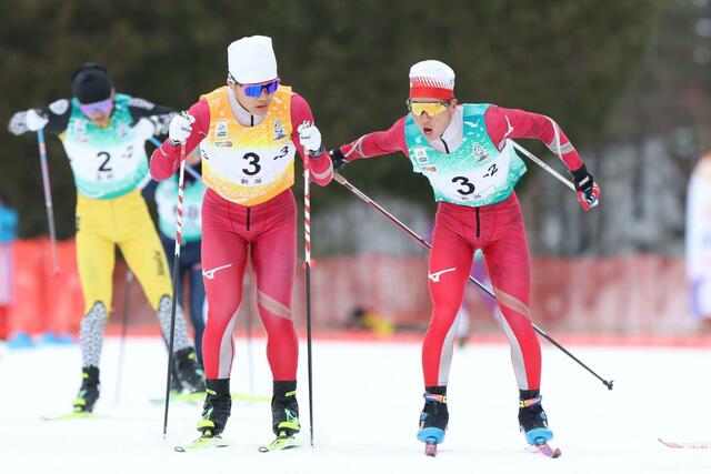 少年男子４０キロリレー　２走岡田幸輝（右・十日町高）が３走丸山由利（同）へリレー＝１７日、青森県大鰐町
