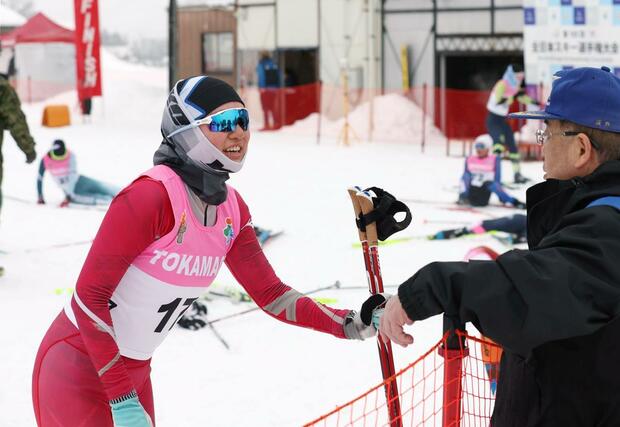女子10キロクラシカル 関係者にねぎらわれ笑顔を見せる福原優香(十日町高)=2月1日、十日町市