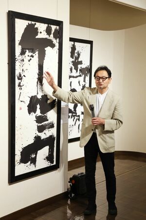 書展の作品について解説する田中藍堂さん=弥彦村弥彦