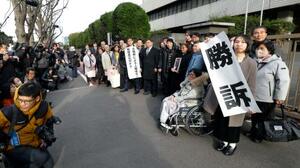 　脱北者ら４人が北朝鮮政府に損害賠償を求めた訴訟の差し戻し審判決で勝訴し、写真に納まる原告ら＝２６日午後、東京地裁