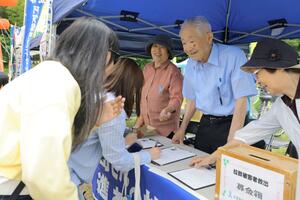 大沢孝司さんの兄・昭一さん(右から2人目)らが特定失踪者の救出を求め行った署名活動=6日、阿賀町