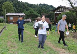 移住を検討する人たちを連れ、津南町内の集落を案内する照井麻美さん=10月5日、津南町赤沢