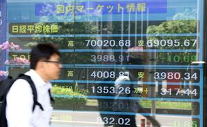 日経平均株価が一時7万円を超えたことを示す株価ボード=16日、長岡市の岡三にいがた証券