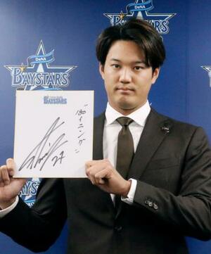 契約交渉を終え、色紙を手にするDeNAの藤浪=8日、横浜市の球団事務所