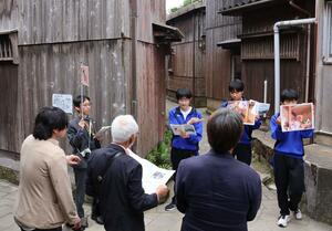 北前船の交易で栄えた集落の伝統的な町並みを案内した南佐渡中の生徒=佐渡市宿根木
