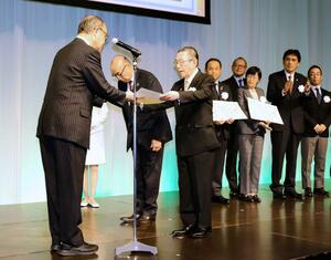 エコレールマーク大賞を受賞し、表彰状を受け取るブルボンの吉田康会長（右）＝１０月、東京