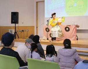 自作の絵本を読み聞かせする「DJみそしるとMCごはん」さん=新発田市諏訪町1