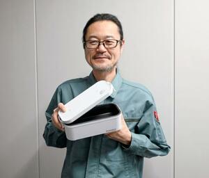 　商品を持つサンコーの新村孝司さん＝東京都千代田区