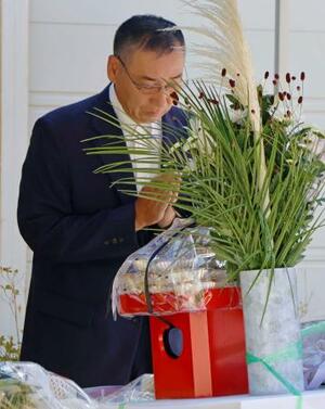 「楽ん楽ん」跡地に設置された献花台で手を合わせる、兄繁喜さんを亡くした千葉利光さん=30日午前、岩手県岩泉町