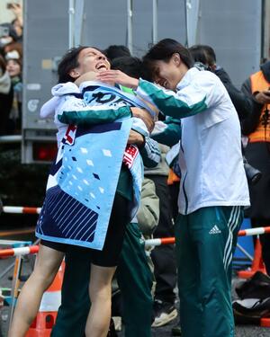 1位でゴールした選手と抱き合い号泣する黒田朝日選手ら青山学院大メンバー=3日、東京・大手町