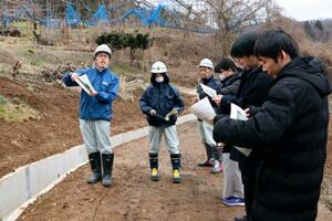 　山形県が開いた職場見学会で、実際の仕事現場を案内する県職員（左）＝２月、山形市